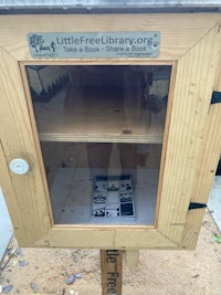 a wooden bookcase with a sign on it